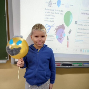 pokaż obrazek - Uczeń trzyma balon