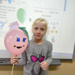 pokaż obrazek - Uczennica trzyma balon